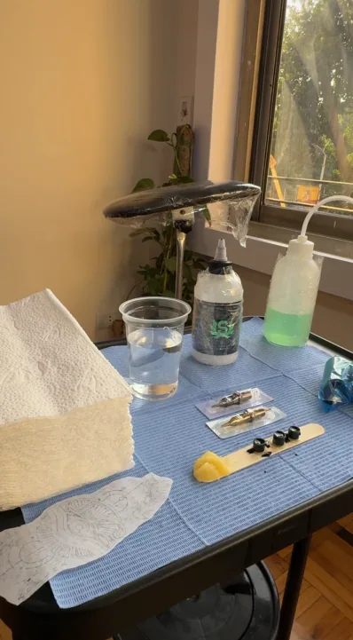 Prepared workstation at MORSE INK with covered tray, towels, and stencil ready before a session